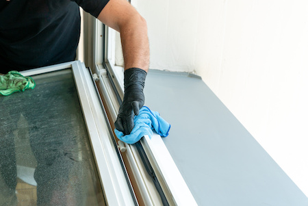 Profesional Cleaner Cleaning A Dirty Window Frame With A Micro Fiber Cloth