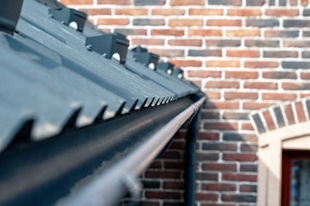 Gutter system for a metal roof. Holder gutter drainage system on the roof.